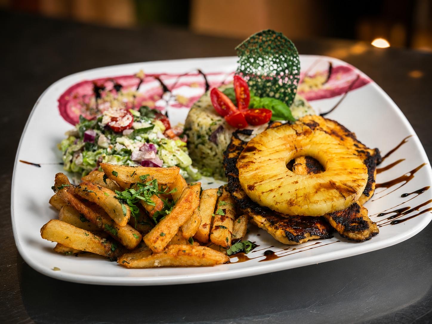 Poulet grillé à l'ananas, salade et riz, dressé en assiette chez Miam's Resto Café